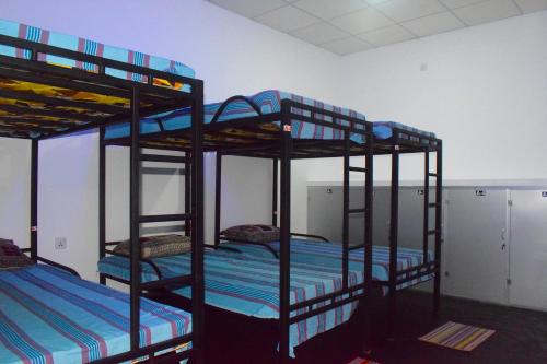 a room with three bunk beds in a room at Hotel Angel Inn Beach in Trincomalee