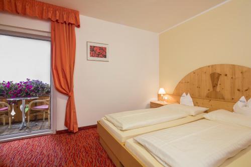 a hotel room with a bed and a window at Hotel Amaten in Brunico