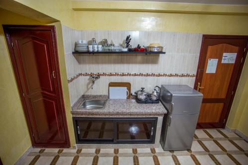 a small kitchen with a sink and a refrigerator at Appart Hotel Les Ambassadeurs in Marrakech