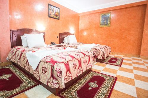two beds in a room with two rugs at Appart Hotel Les Ambassadeurs in Marrakech