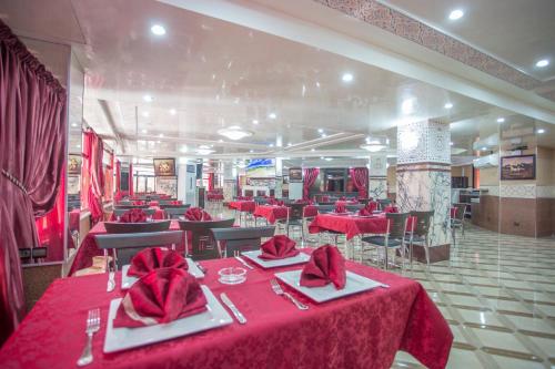 a restaurant with red tables and chairs with red napkins at Appart Hotel Les Ambassadeurs in Marrakech