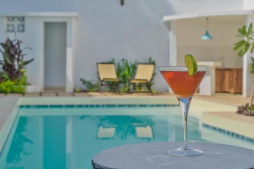 a drink sitting on a table next to a swimming pool at The Seyyida Hotel and Spa in Zanzibar City