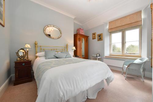 a bedroom with a large bed and a window at Heritage Bed and Breakfast in Calne