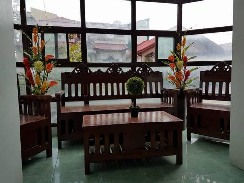 a restaurant with benches and a table with a plant on it at N&J Lopez Lodging House in Manila