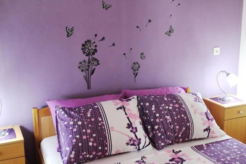 a bedroom with a bed with butterflies on the wall at Apartment Teraferma in Komiža