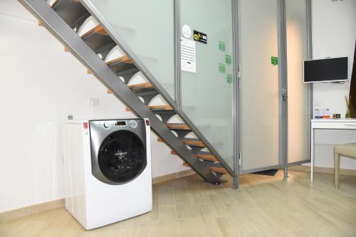 a washing machine in a room with a staircase at B&B Quintino Sella in Iglesias