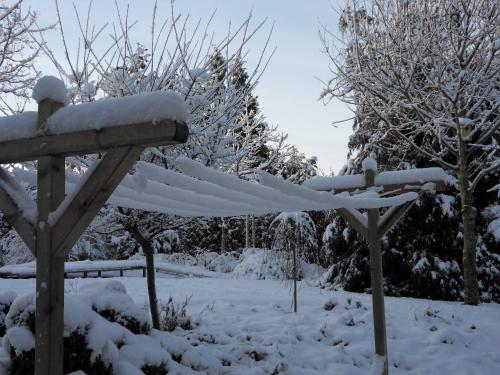 a bench covered in snow with trees in the background at Bed and Breakfast Birkerod in Birkerød