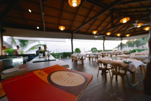 a restaurant with tables and chairs and a menu at Sita Beach Resort in Ko Lipe