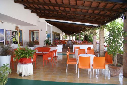 a restaurant with orange chairs and tables in a room at Hotel Cristina in Diamante