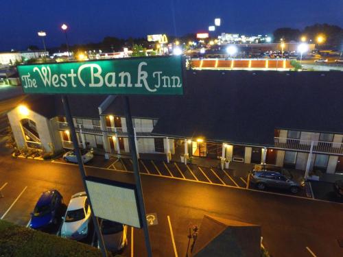 a street sign in front of a parking lot at night at West Bank Inn in Augusta