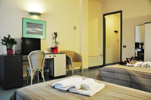 a hotel room with two beds and a desk at L'Approdo di Angelino in Pizzolungo