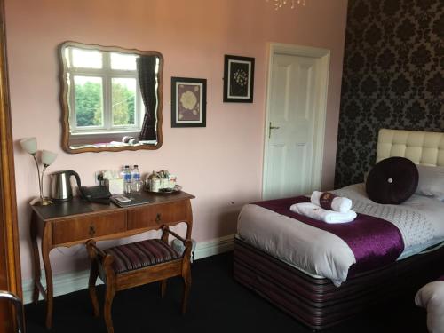 Ein Bett oder Betten in einem Zimmer der Unterkunft Grimscote Manor Hotel