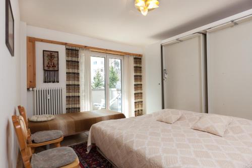 a bedroom with a bed and a desk and a window at Chesa Derby 3 in Sankt Moritz-Bad