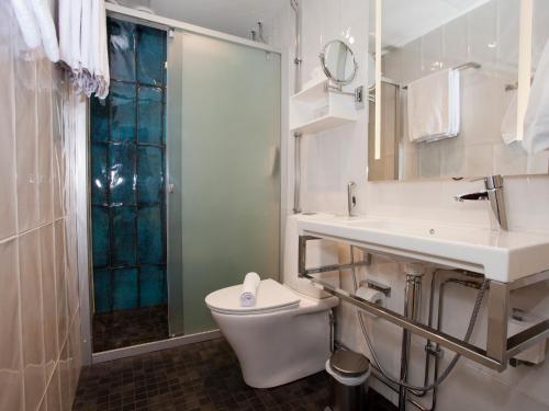a bathroom with a toilet and a sink and a shower at Original Sokos Hotel Puijonsarvi in Kuopio