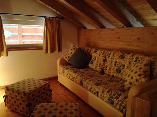 a living room with a couch and a window at Hotel Ca' del Bosco in Selva di Cadore