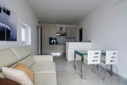 a living room with a white couch and a table at Residence Il Poggio in Dorio