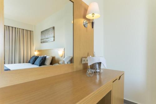 a hotel room with a bed and a large mirror at City Center Hotel in Rhodes Town