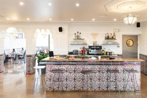 - une cuisine avec un bar et un comptoir dans l'établissement Hôtel Le Saint Germain, à Aulnay-sous-Bois