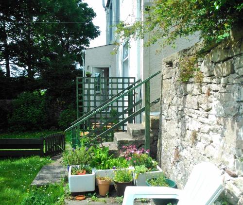 a house with a staircase and some plants in a yard at Rose cottage in Millport