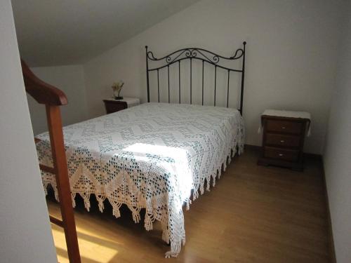 a bedroom with a bed with a black and white bedspread at casa d'Azoia in Sesimbra