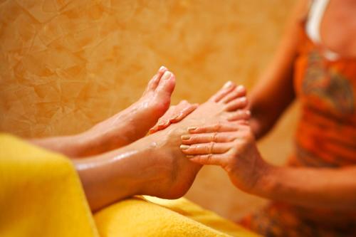 two people sitting on a couch with their feet up at Hotel Berghof in Pfronten