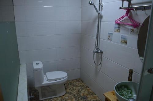 a small bathroom with a toilet and a shower at Yangjiajie Inn in Zhangjiajie