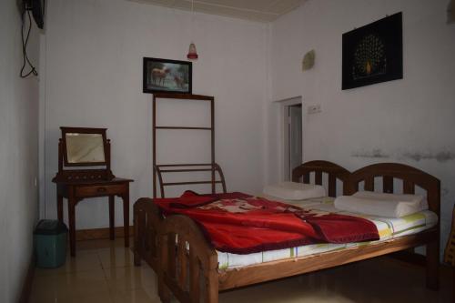 a bedroom with a bed and a mirror and a table at Highcliffe Guest House in Haputale