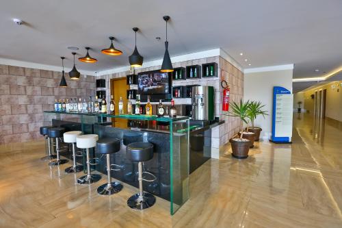a bar with bar stools in a room at Ibiza Plaza Hotel in Anápolis