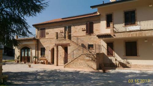 a large stone building with stairs in front of it at Agriturismo Fonte Carra in Grottazzolina