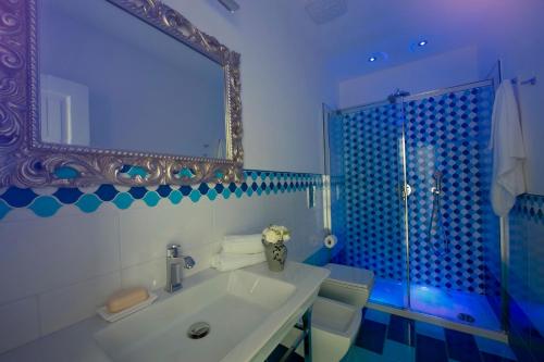 une salle de bain avec un lavabo et un miroir et des toilettes dans l'établissement La Valle Delle Ferriere, à Amalfi