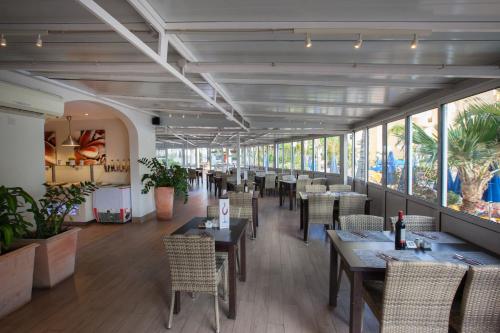 a dining room with tables and chairs and windows at Grupotel Monte Feliz in San Agustin