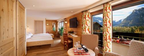 a hotel room with a bed and a large window at Hotel Berghof in Pfronten