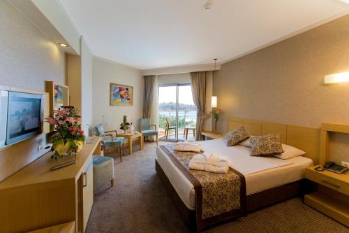 een hotelkamer met 2 bedden en een televisie bij Saphir Resort & Spa in Okurcalar
