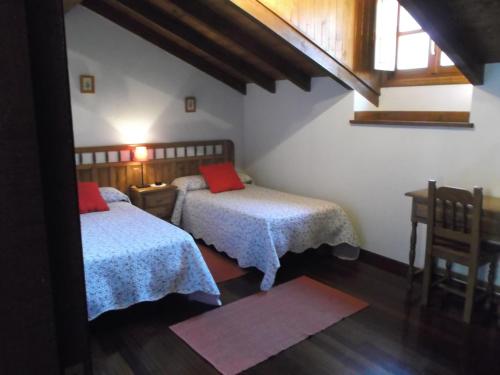 a bedroom with two beds and a table and a window at Posada Casa Molleda in Pejanda