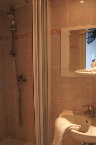 a bathroom with a shower and a sink at Hôtel De La Cathédrale in Reims