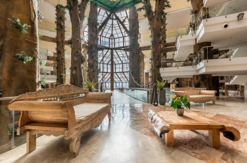 a large room with wooden benches and trees at Holiday World Polynesia in Benalmádena