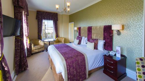 a hotel room with a large bed and a television at The Imperial Hotel in Barnstaple