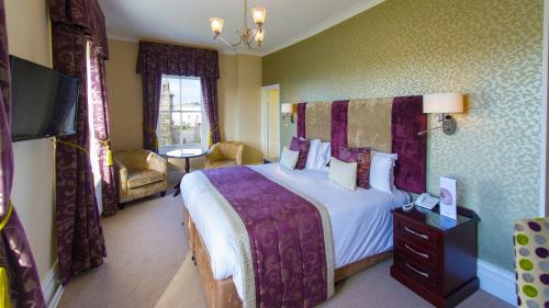 a hotel room with a bed and a dresser at The Imperial Hotel in Barnstaple