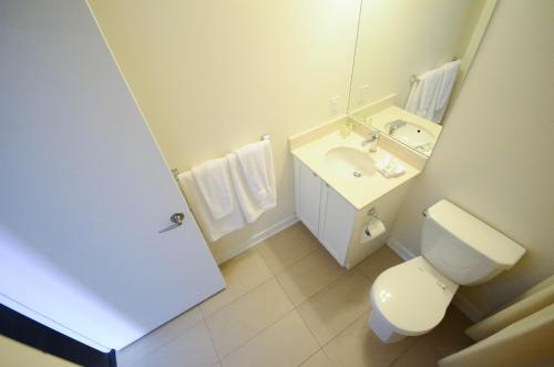 a bathroom with a toilet and a sink and a mirror at Executive Furnished Properties - Square One Mississauga in Mississauga