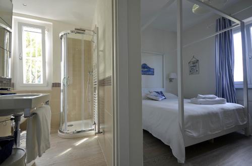 a bathroom with a shower and a bed and a sink at Villa Porto sul Magra in Ameglia