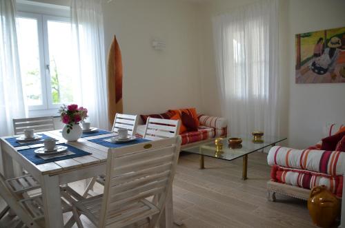 ein Wohnzimmer mit einem Tisch, Stühlen und einem Sofa in der Unterkunft Villa Porto sul Magra in Ameglia
