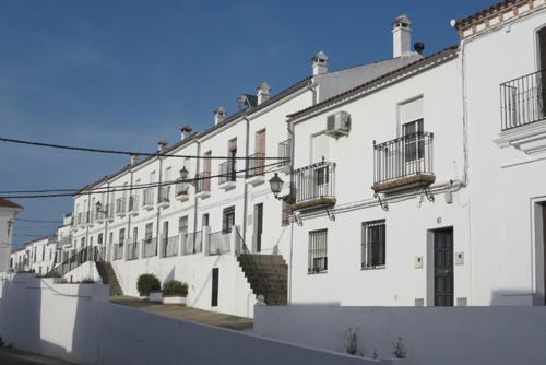 un gran edificio blanco con escaleras y balcones. en La Casa de Manolo, en Cazalla de la Sierra