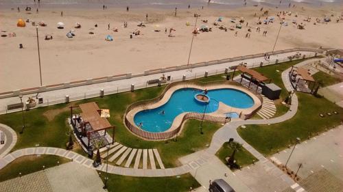 an aerial view of a swimming pool next to a beach at Departamento Horizonte Playa la Herradura in Coquimbo