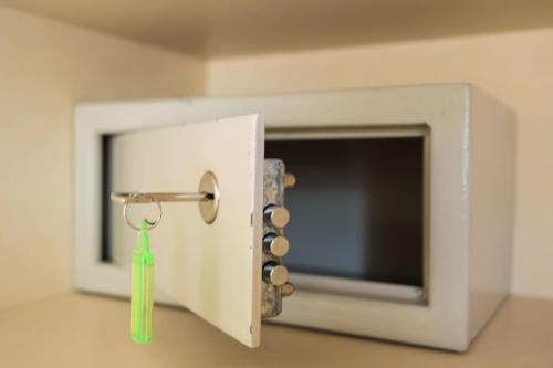 a white microwave with a green key in it at Dina Apartments in Razáta