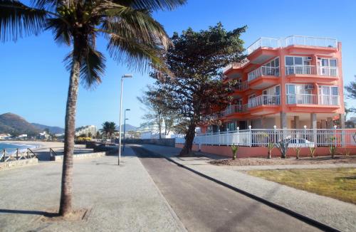 a building on the beach with palm trees in front of it at KS Beach Hotel in Rio de Janeiro