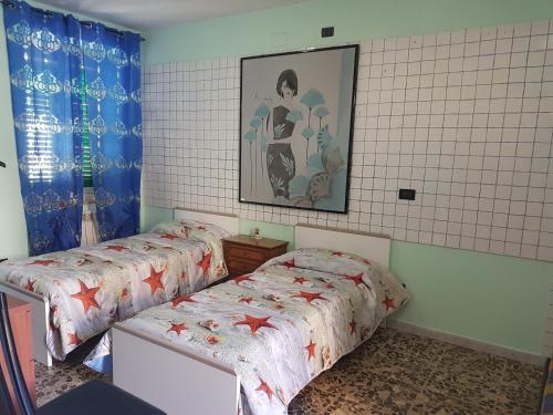 ManoppelloにあるLa Casetta Di Via Faraのベッドルーム1室(ベッド2台付)が備わります。壁に絵が描かれています。