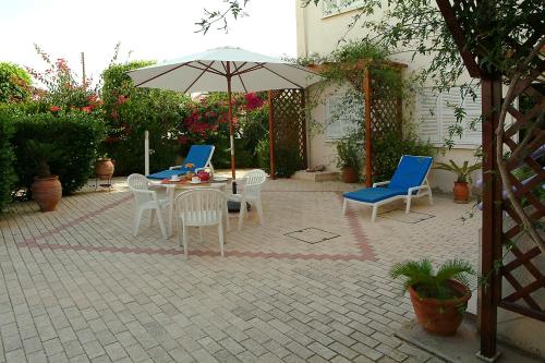 a patio with a table and chairs and an umbrella at Sunbay Apartments in Pyla