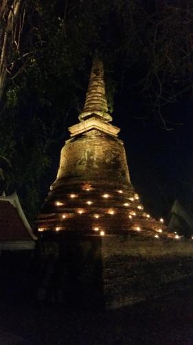 a large pagoda with lights on it at night at Vitoonguesthouse2fanrooms & Aircondition in Sukhothai