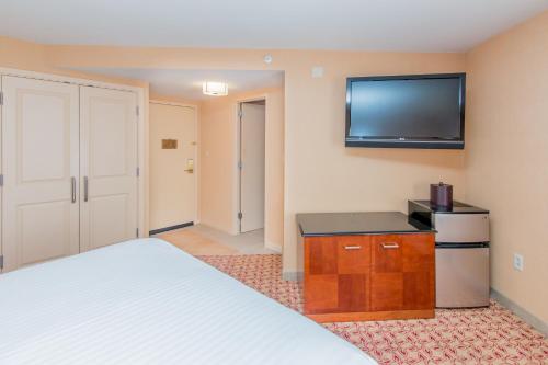a bedroom with a bed and a flat screen tv at Doubletree By Hilton Battle Creek in Battle Creek