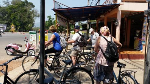 a group of people standing outside a store with their bikes at Vitoonguesthouse2fanrooms & Aircondition in Sukhothai